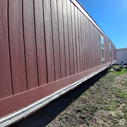 Vertical wood-grain siding finished in a deep red tone featuring inset windows with light-colored trim