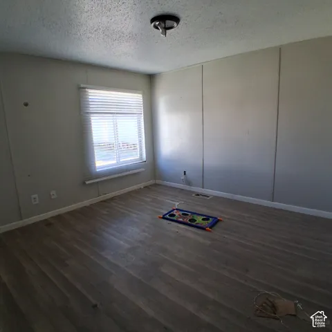 Interior space featuring wood-finish flooring, panelled walls, and a window with horizontal blinds