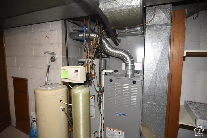 Mechanical utility area featuring a high-efficiency furnace, water softener system, water heater, and metal ductwork