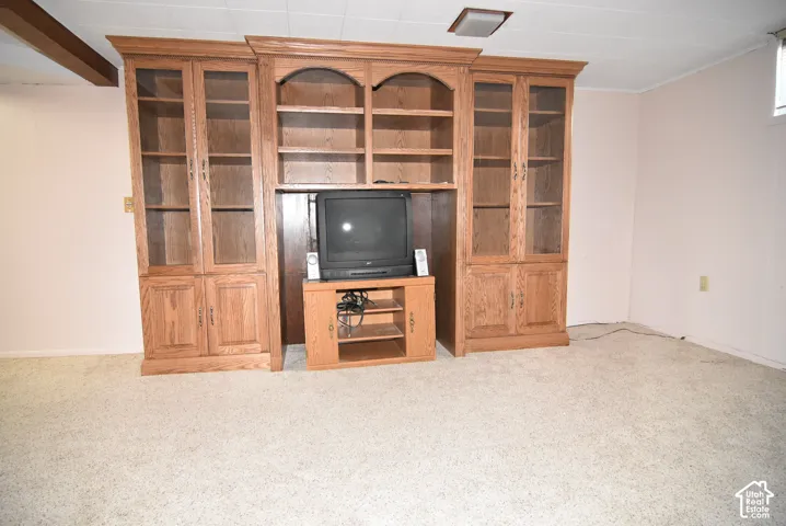 Custom floor-to-ceiling oak cabinetry featuring integrated shelving, glass-panel cabinet doors, and lower storage compartments