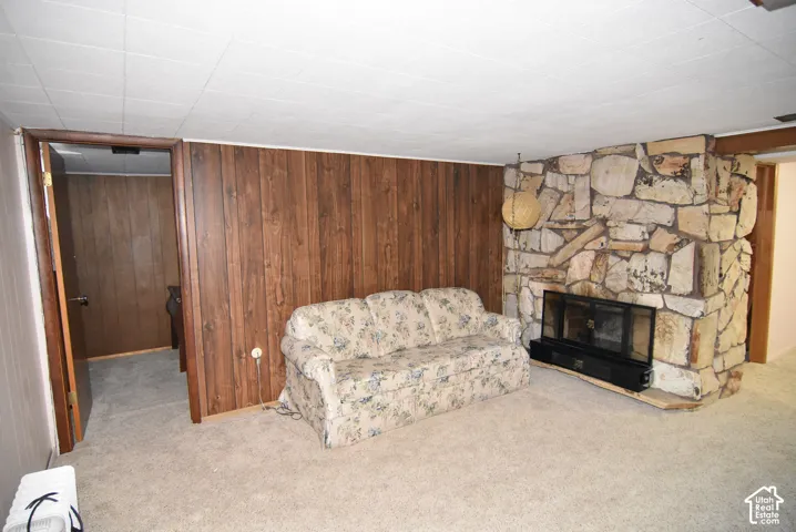 Floor-to-ceiling natural stone fireplace with a raised hearth, wood-panelled accent wall, and recessed ceiling lighting