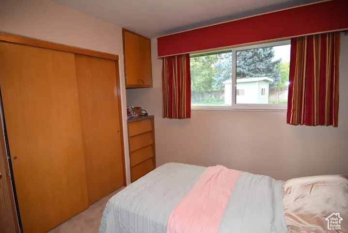 Bedroom #2 Built-in wood-finish cabinetry, floor-to-ceiling sliding closet doors, and large sliding window