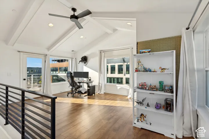 Vaulted ceilings with exposed beams, wood-finish flooring, recessed lighting, matte black ceiling fan, and metal spindle railing