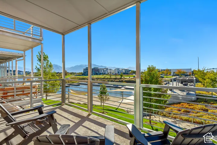 Covered balcony featuring metal railing, concrete flooring, and mountain backdrop
