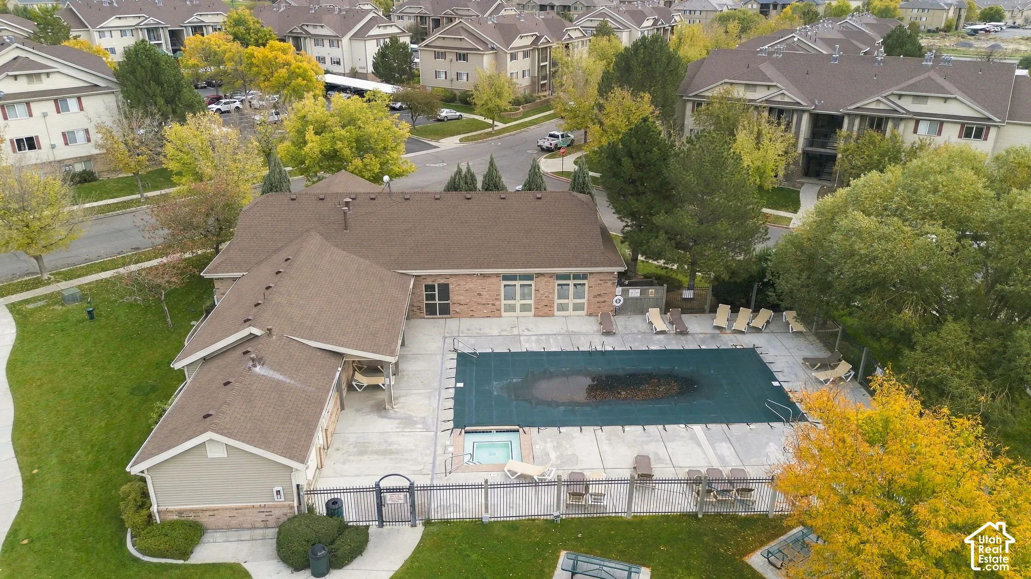 Community recreation center featuring an outdoor swimming pool, integrated spa, paved concrete deck, and perimeter fencing
