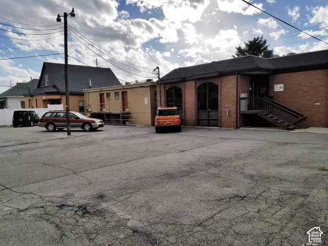 Brick-exterior commercial building featuring arched window encasements and a wooden staircase