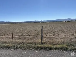 Expansive acreage featuring level topography, post-and-wire fencing, and a mountain backdrop