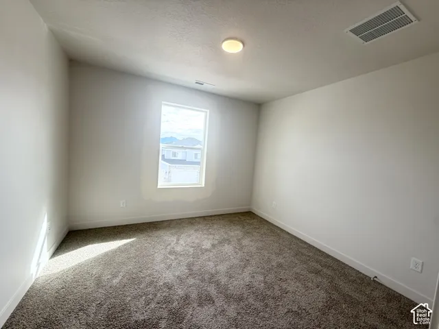 Neutral-toned interior space featuring neutral wall paint, wall-to-wall carpeting, and a single-pane window