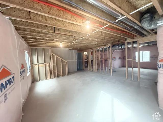 Unfinished lower level featuring exposed wood joist ceilings, concrete flooring, insulated wall barriers, and wooden wall framing