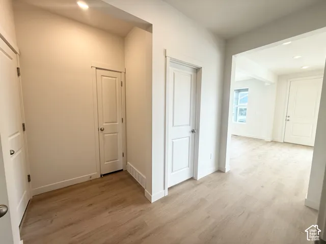 Interior space featuring wood-finish flooring, two-panel interior doors, and recessed lighting