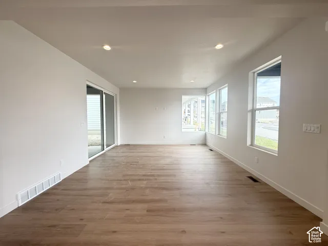 Open-concept room featuring wood-finish flooring, recessed lighting, expansive windows, and a sliding glass door