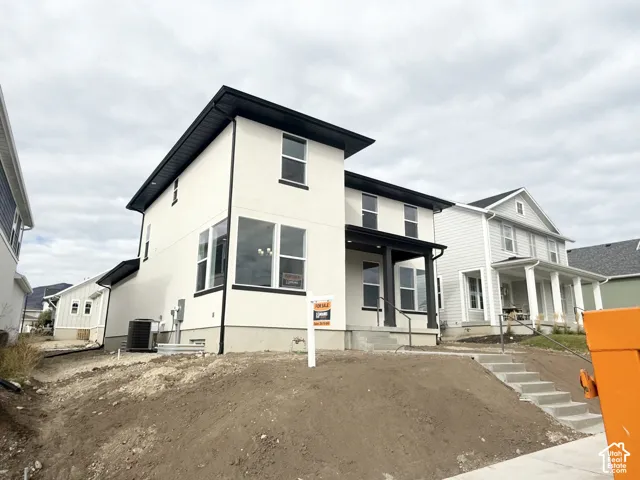 Two-story modern exterior featuring smooth stucco siding, dark window frames, an attached covered porch, and concrete entry steps