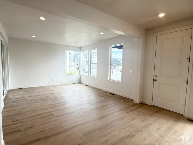 Interior room featuring wood-finish flooring, recessed lighting, white walls, and multiple large windows