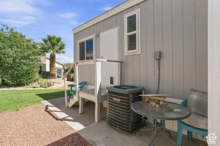 Vertical paneled exterior siding with dual-pane windows, elevated platform entry, and exterior HVAC unit