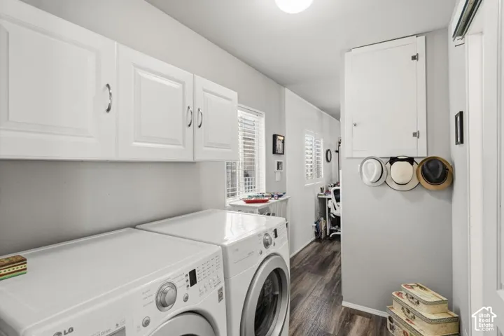 Utility area featuring white shaker-style wall cabinets, wood-finish flooring, and white louvered window shutters