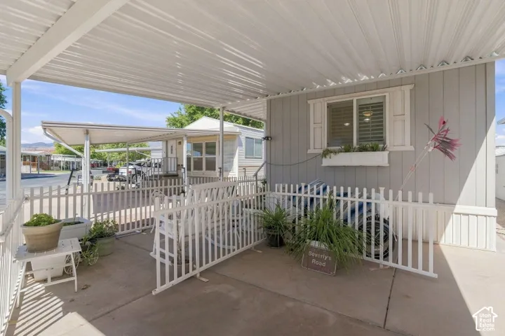 Covered patio featuring concrete flooring, a white metal privacy fence, and a built-in window box