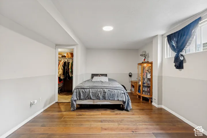 Room featuring wood-finish flooring, two-tone wall paint, recessed ceiling lighting, clerestory-style windows, and a built-in reach-in closet