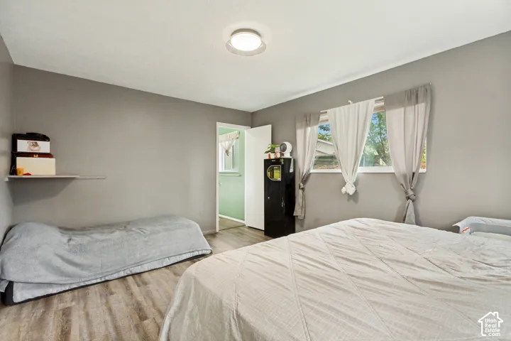 Room featuring neutral gray walls, wood-finish flooring, a flush-mount ceiling light fixture, and a single-pane window