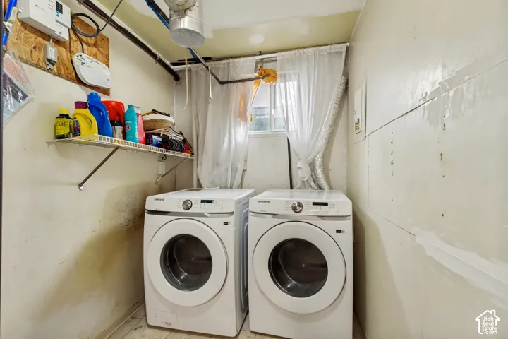 Utility area featuring front-loading laundry appliances and a wall-mounted metal storage shelf