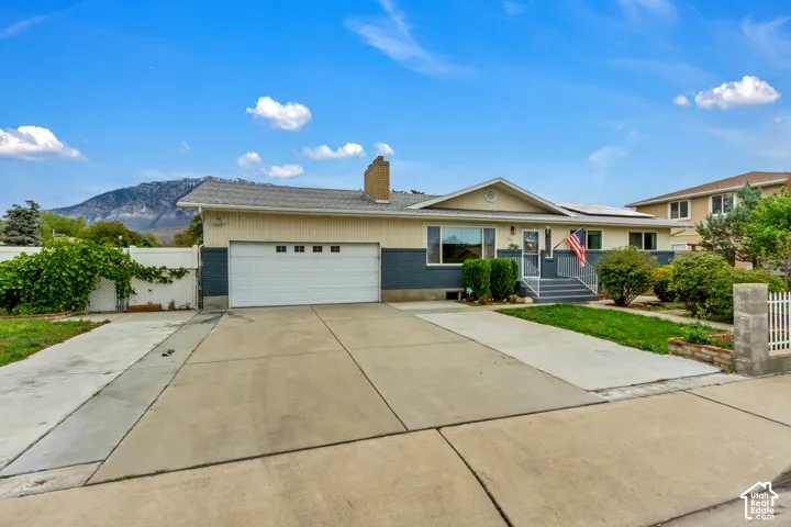 Exterior featuring a brick and horizontal siding facade, two-car garage, concrete driveway, and mountain backdrop