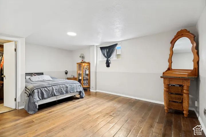 Wood-finish flooring, recessed ceiling lighting, and a walk-in closet with an interior door