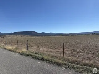Expansive open acreage featuring mountain scenery and wire perimeter fencing