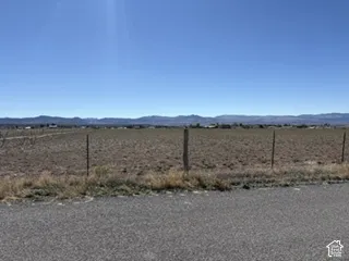 Expansive level parcel featuring mountain backdrops and perimeter wire fencing