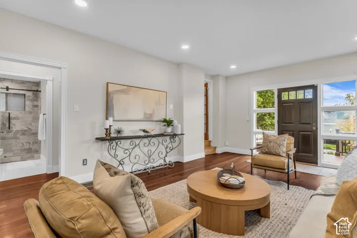 Living area featuring wood-finish flooring, recessed lighting, and a multi-pane front door with side glass panels