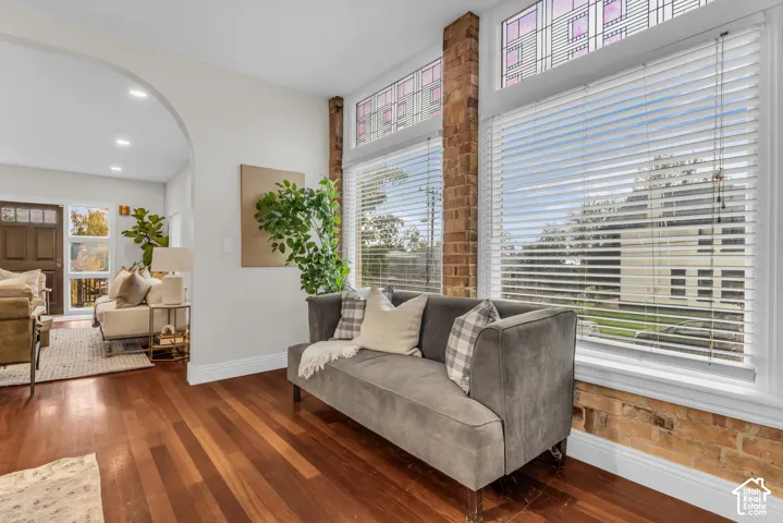 Wood-finish flooring, exposed brick pillars, stained glass transom windows, and an arched entry