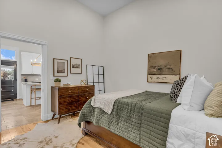 High-ceiling interior space featuring neutral wall paint, wood-finish flooring, and white cased door frames