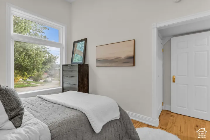 Neutral-toned interior featuring hardwood flooring, large multi-pane window, and a paneled door with metallic hardware