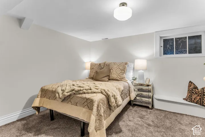 Neutral-toned walls, plush wall-to-wall carpeting, recessed window with white trim, and a centered flush-mount ceiling light fixture