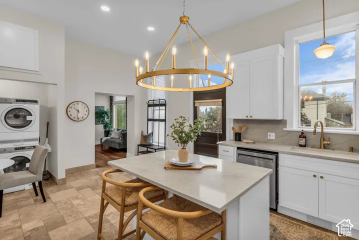 Kitchen featuring white shaker-style cabinetry, quartz countertops, a central island, recessed lighting, and a gold-tone wagon wheel chandelier