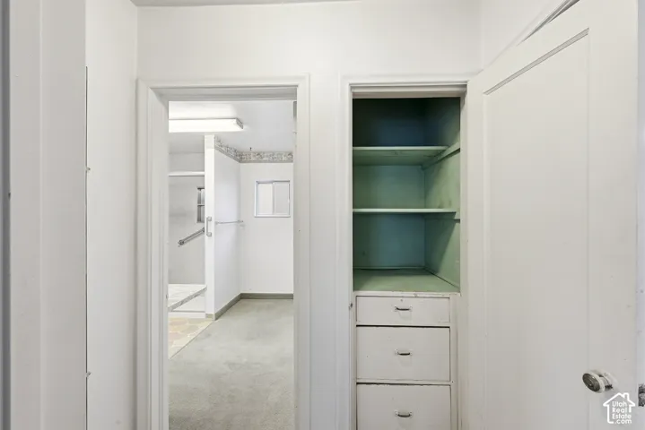 Built-in storage cabinet featuring three pull-out drawers and fixed shelving
