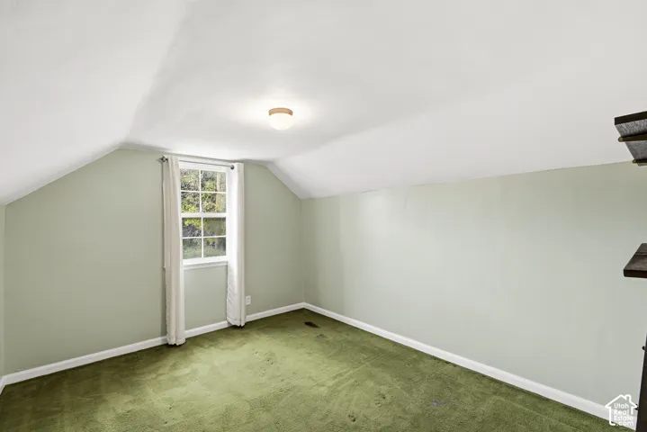 Sloped ceilings, single-hung window with a grid pattern, and flush-mount ceiling light