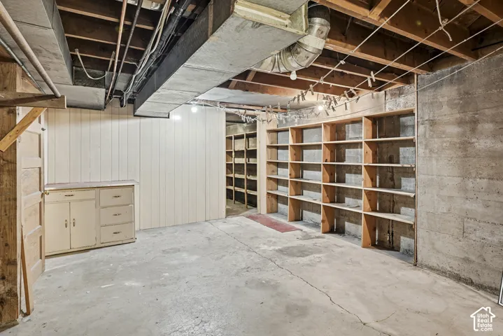 Storage space featuring built-in wooden shelving units and a standalone cabinet with drawers