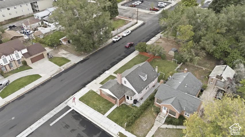 Aerial perspective of the property featuring a gabled roofline, brick masonry exterior, chimney, and detached structure