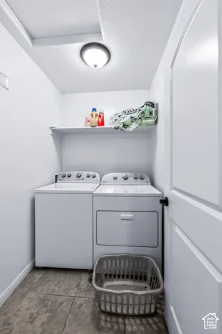 Dedicated laundry area featuring tile flooring, a built-in storage shelf, and a flush-mount ceiling light fixture
