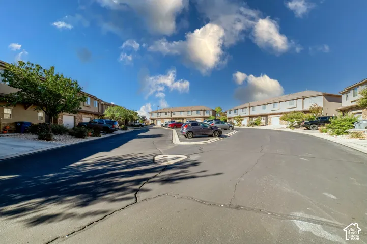 Multi-unit residential complex featuring asphalt streets, attached garages, stone veneer accents, and stucco siding