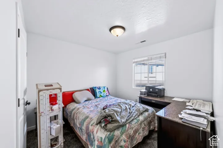 Neutral walls, carpeted flooring, window with installed blinds, and a central ceiling-mounted light fixture