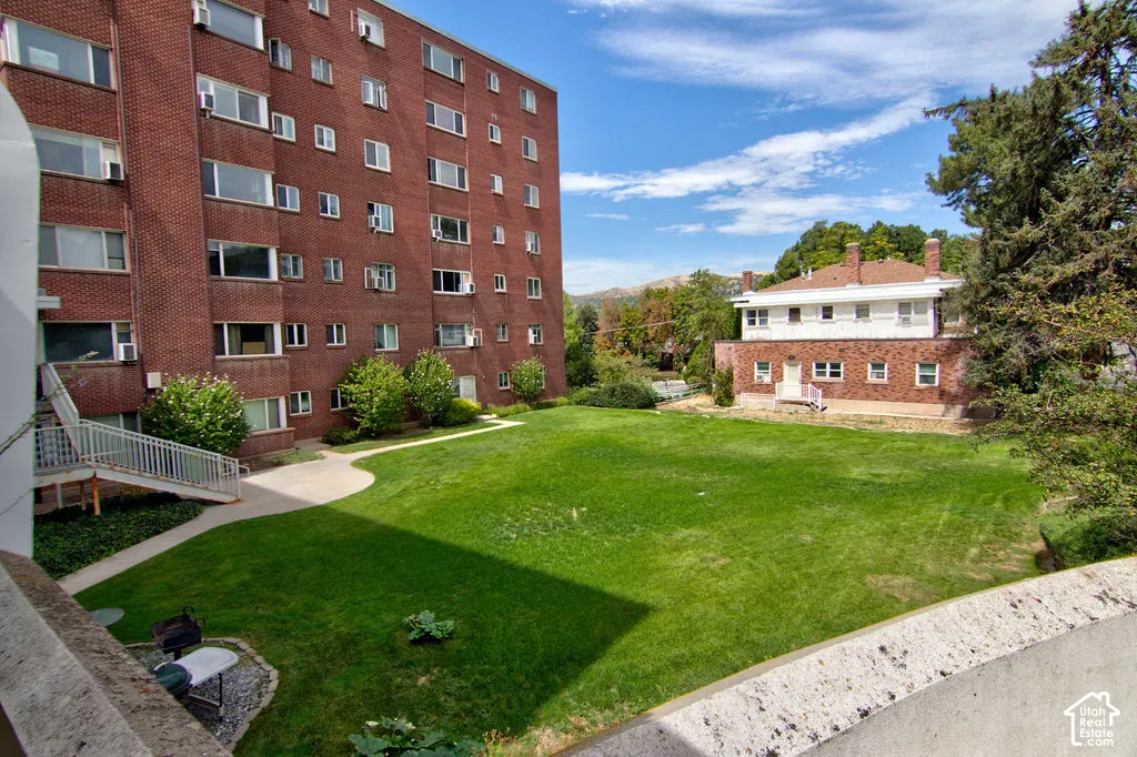 Expansive central lawn featuring mature trees and concrete pathways, flanked by multi-story brick residential buildings