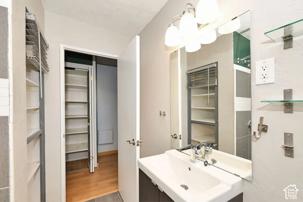 Bathroom vanity with rectangular vessel sink, polished chrome faucet, and integrated mirror, featuring wall-mounted glass shelving and built-in recessed storage