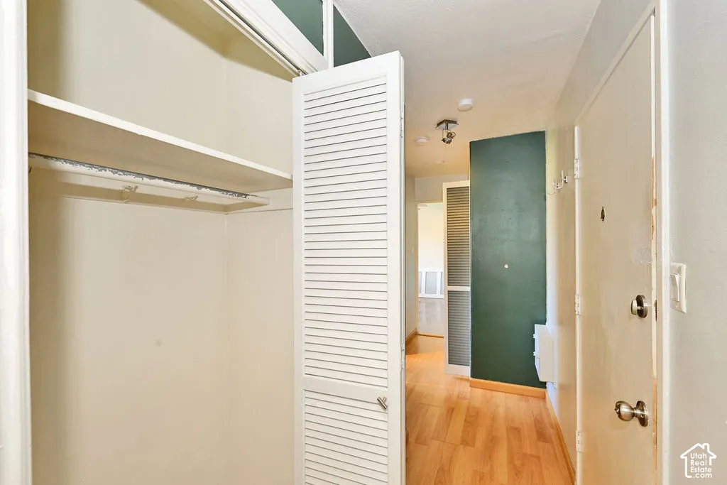 Entryway featuring wood-finish flooring, white louvered closet doors, and recessed ceiling lighting