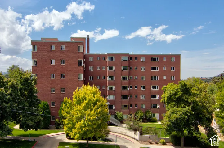 Mid-rise multi-story structure featuring a red brick exterior, flat roofline, and paved circular drive