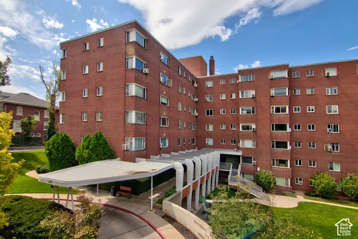 Multi-story brick exterior featuring a covered porte-coch
