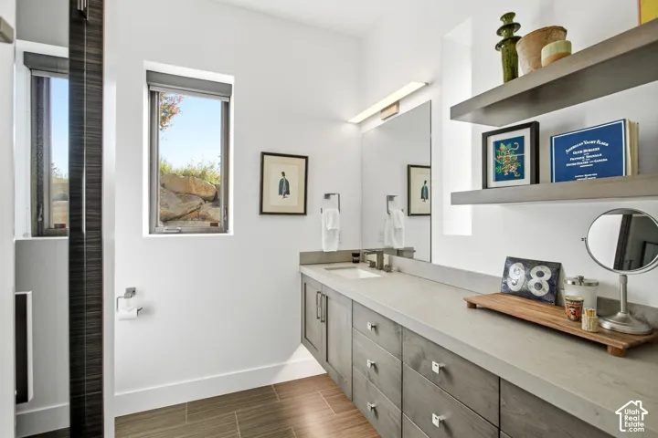 Floating vanity with gray wood-finish cabinetry, stone-style countertop, rectangular undermount sink, and two tiered floating shelves