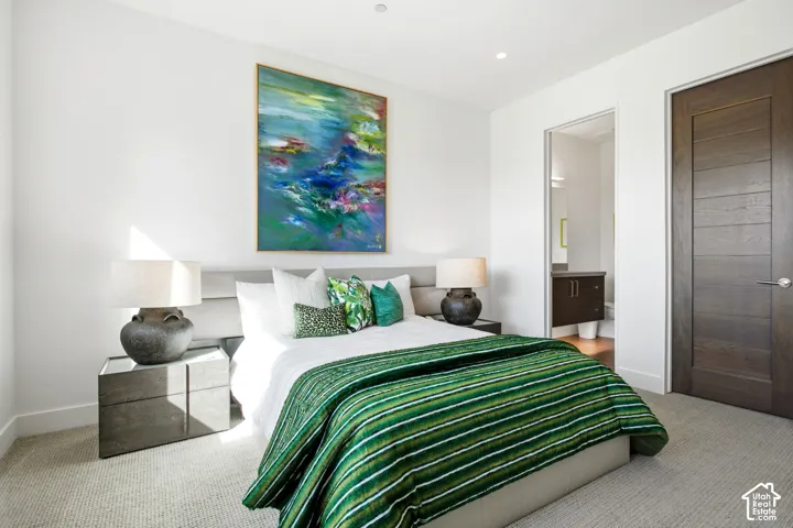 Neutral-toned carpeting, recessed ceiling lighting, and a horizontal-paneled dark wood door