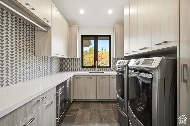 Utility room featuring floor-to-ceiling light-toned cabinetry, geometric patterned tile backsplash, solid-surface countertops, under-counter beverage cooler, and recessed lighting