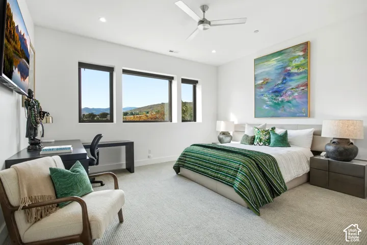 Spacious room featuring neutral carpeting, triple-pane window configuration, recessed lighting, and a modern ceiling fan