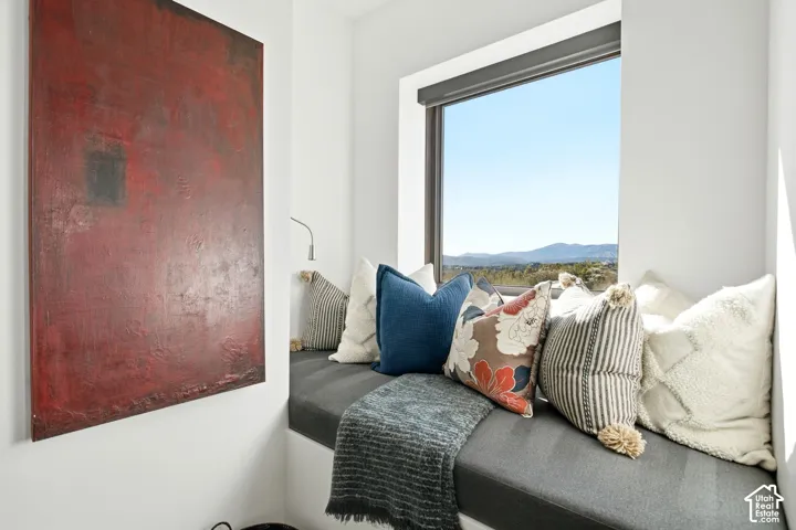 Built-in window seat featuring a dark grey upholstered cushion, expansive rectangular window, and mountain scenery